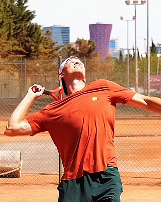 Pavel Viks with the racket dropped behind his back, edge first